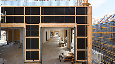 Photo of the VINZENT building shell in Munich. A timber frame construction element can be seen.