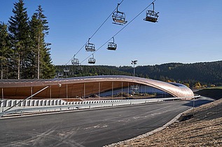 Foto einer Rodelbahn. Man sieht auch einen Sessellift im Bild.
