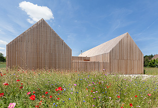 Photo of a modern wooden house in U-shape with wooden facade. LENO-BSP.