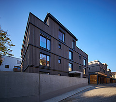 Photo of a multi-storey residential building with a wooden façade.