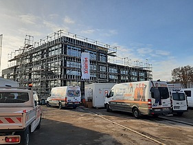 Außenaufnahme des Rohbaus Büro ZÜBLIN Neu-Ulm. Man sieht ein eingerüstetes Gebäude aus Holz.