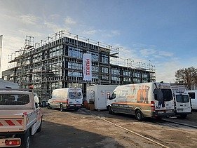 Exterior shot of the ZÜBLIN Neu-Ulm office shell. You can see a scaffolded wooden building.