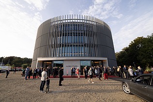 Photo of the Globe Theater in Coburg on opening day. You can see a round building made of wood.