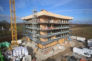 Foto eines mehrgeschossigen Holzbaus während der Montage.