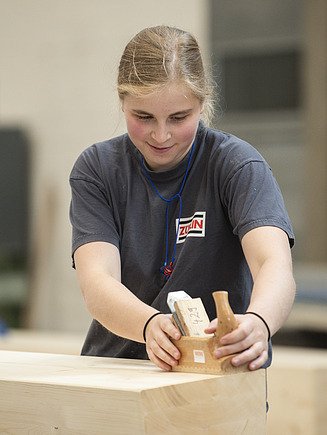 Photo of an apprentice carpenter sanding wood.