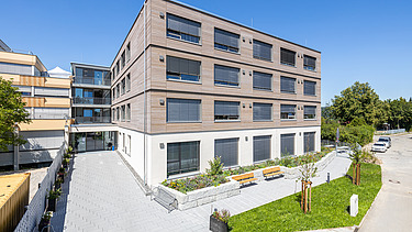 Foto einer Außenaufnahme der Seniorenwohnanlage Elias-Schrenk-Haus, Tuttlingen. Das Gebäude hat eine Holzfassade.