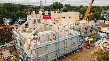 Foto der Montage der Universität Witten-Herdecke. Man sieht LENO-Brettsperrholzelemente die gerade montiert werden.