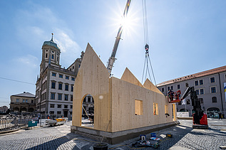 Photo of the NEXT500 pavilion on Augsburg's market square. You can see the assembly of the LENO elements.