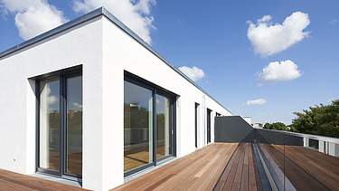 Foto eines Terrassenausschnittes einer Aufstockung mit Flachdach.