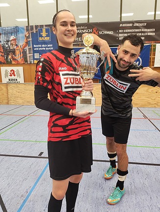 Zwei Personen. Firmen- und Behördencup in der Turnhalle. Fußballspiel.