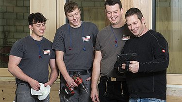 Photo of four carpenters in production at ZÜBLIN Timber