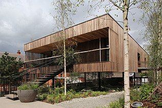 Photo of a wooden building with flat roof and large staircase.