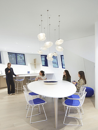 Interior view of the Maggie Center in London. You can see a lounge with people.