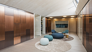 Foto der Anwaltskanzlei FGS Augsburg. Moderner Innenraum mit vielen Holzoberflächen und Sitzsäcken.