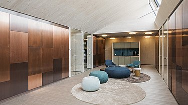 Photo of the FGS Augsburg law firm. Modern interior with many wooden surfaces and beanbags.