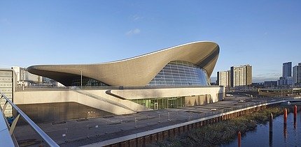 Photo of the Aquatics Center in London from the outside. You can see the wooden roof construction.