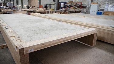 Photo of a horizontal rib element in the ZÜBLIN Timber production hall.