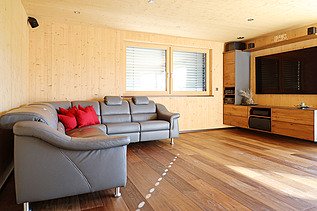 Photo of a house made of LENO cross laminated timber. Living room with many wooden surfaces.