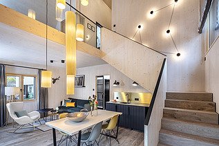 Photo of the furnished living room of the Chalet Engel in Baiersbronn. Many wooden surfaces can be seen.