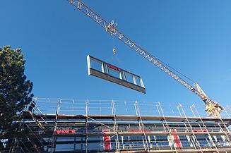 Montage eines Holzrahmenbauelements. Projekt WTH Wertheim Foto einer Montage eines Holzrahmenbauelements. Man sieht ein schwebendes Element am Kan.