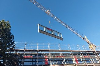 Montage eines Holzrahmenbauelements. Projekt WTH Wertheim Foto einer Montage eines Holzrahmenbauelements. Man sieht ein schwebendes Element am Kan.
