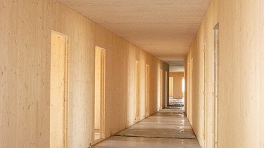 Photo of a hallway in the shell. You can see many LENO cross-laminated timber surfaces.