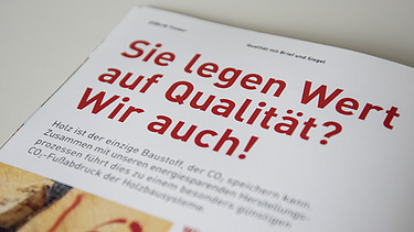 Foto der Innenseite der Broschüre Holzbauelemente von ZÜBLIN Timber. Man sieht eine Baumscheibe und die Überschrift Sie legen Wert auf Qualität? Wir auch!