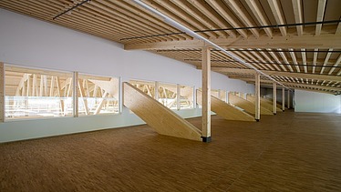 Photo of the Pilatus CH-Stans assembly hall. A glulam roof construction can be seen.
