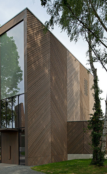Church KGK Immanuelkirche Cologne Photo of an exterior shot of the Immanuel Church in Cologne. This has a wooden façade and a flat roof and a wooden extension on each side.