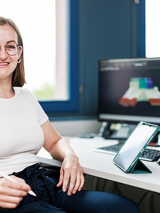 Photo of a woman at a computer workstation.