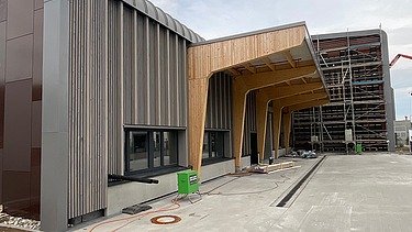 Photo of the Erbe construction site in Rangendingen. You can see large glulam beams at the entrance area.