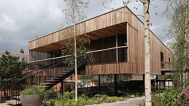 Photo of a wooden building with flat roof and large staircase.