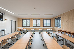 Innenaufnahme der Schule in Erfurt. Man sieht ein Klassenzimmer und eine LENO-ADD-Holz-Außenwand.