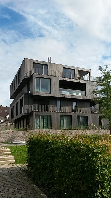 Photo of a multi-storey residential building with a wooden façade.