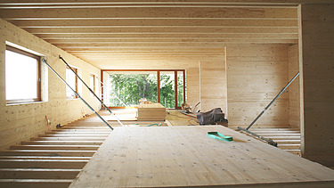 Photo of a timber building shell. The photo shows LENO cross-laminated timber walls and a ribbed timber ceiling.