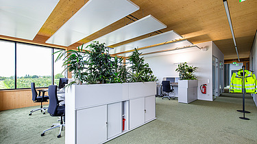 Foto eines modernen, möblierten Büroinnenraumes mit Holzdecke.