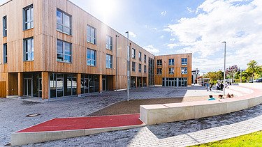 Photo of Witten University from the outside. You can see a large wooden building.