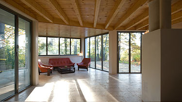 Foto eines modernen Holzhaus. LENO-BSP. Möblierter Wohnbereich innen.