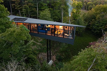 Wohnhaus Vancouver Foto eines Wohnhauses aus Holz auf Stahlpfählen, inmitten des Waldes.