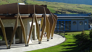 Photo of the Hotel Alpina Dolomites Seiser Alm. You can see a building with striking wooden façade elements made of FSH.