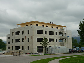 Foto der Montage der Aufstockung des NOVA Centers in Bad Tölz. Zu sehen ist ein mehrgeschossiges Gebäude.