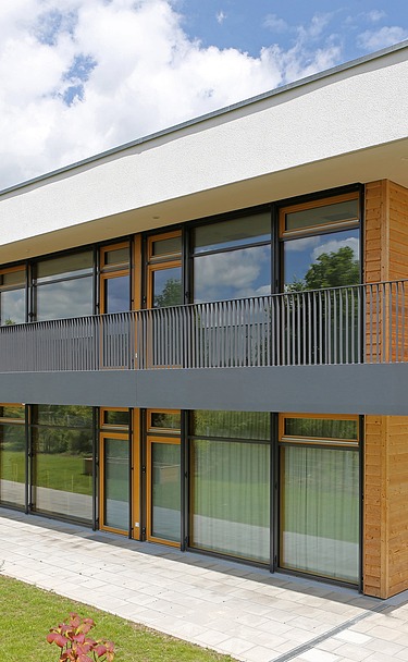 Exterior shot of the daycare center in Frankfurt. You can see a wooden building with a flat roof.