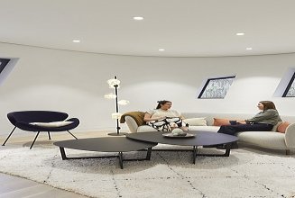 Innenansicht des Maggie Center in London. Man sieht einen Aufenthaltsraum mit zwei Personen auf der Couch sitzen.