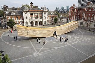 Foto vom Marktplatz und von der geschwungenen Holzskulptur The Smile in London. Der Holzkasten ist begehbar und soll einen lachenden Mund darstellen.