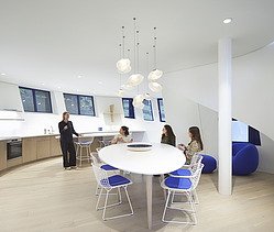 Photo of a recreation room. Four women are in the room. Three are sitting, one is standing.