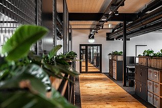 Photo of an interior of the Maisel brewery in Bayreuth. You can see a hallway with a wooden ceiling and floor.