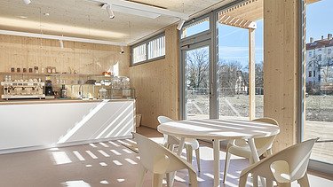 Photo of an interior with many wooden surfaces, glass front and counter.