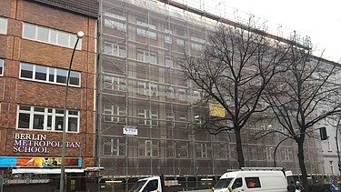 Photo of the wooden extension to the Metropolitan School Berlin. You can see a large multi-storey building.