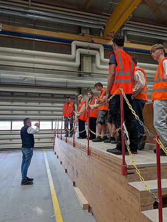 Photo of the new trainees wearing high-visibility vests during a company tour.