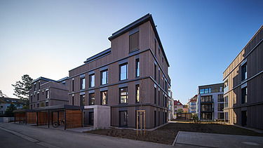 Photo of a multi-storey residential building with a wooden façade.